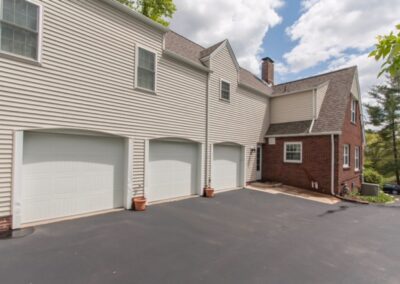 A residential home with a triple garage on a clear day.