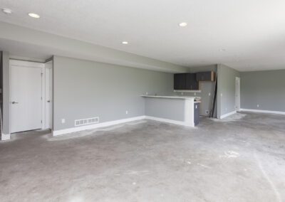 Empty room with newly constructed kitchenette and gray walls.