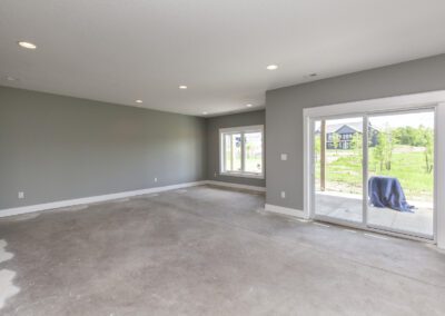 Unfurnished room with concrete flooring and sliding glass door leading to the backyard.