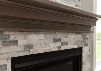 Close-up of a stone fireplace with a wooden mantel.