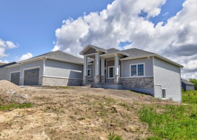 New suburban house under a blue sky with unfinished landscaping.